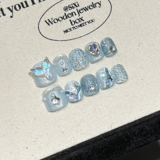 Set of blue glittery earrings on a branded wooden jewelry box